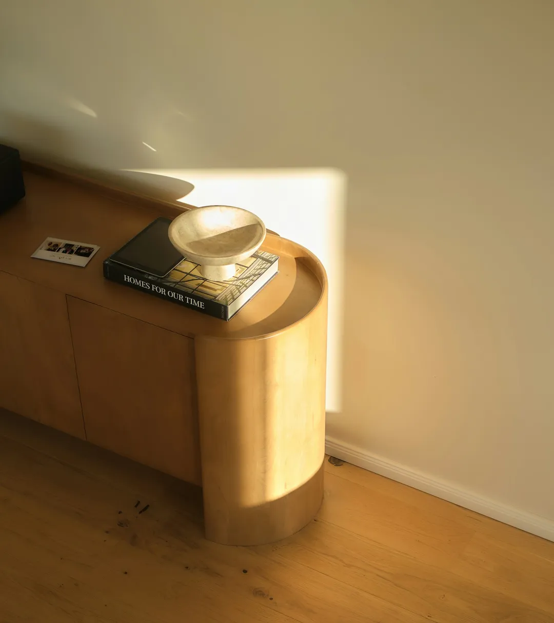 Ambiente interior con luz cálida sobre madera y tonos marfil — imagen provisional